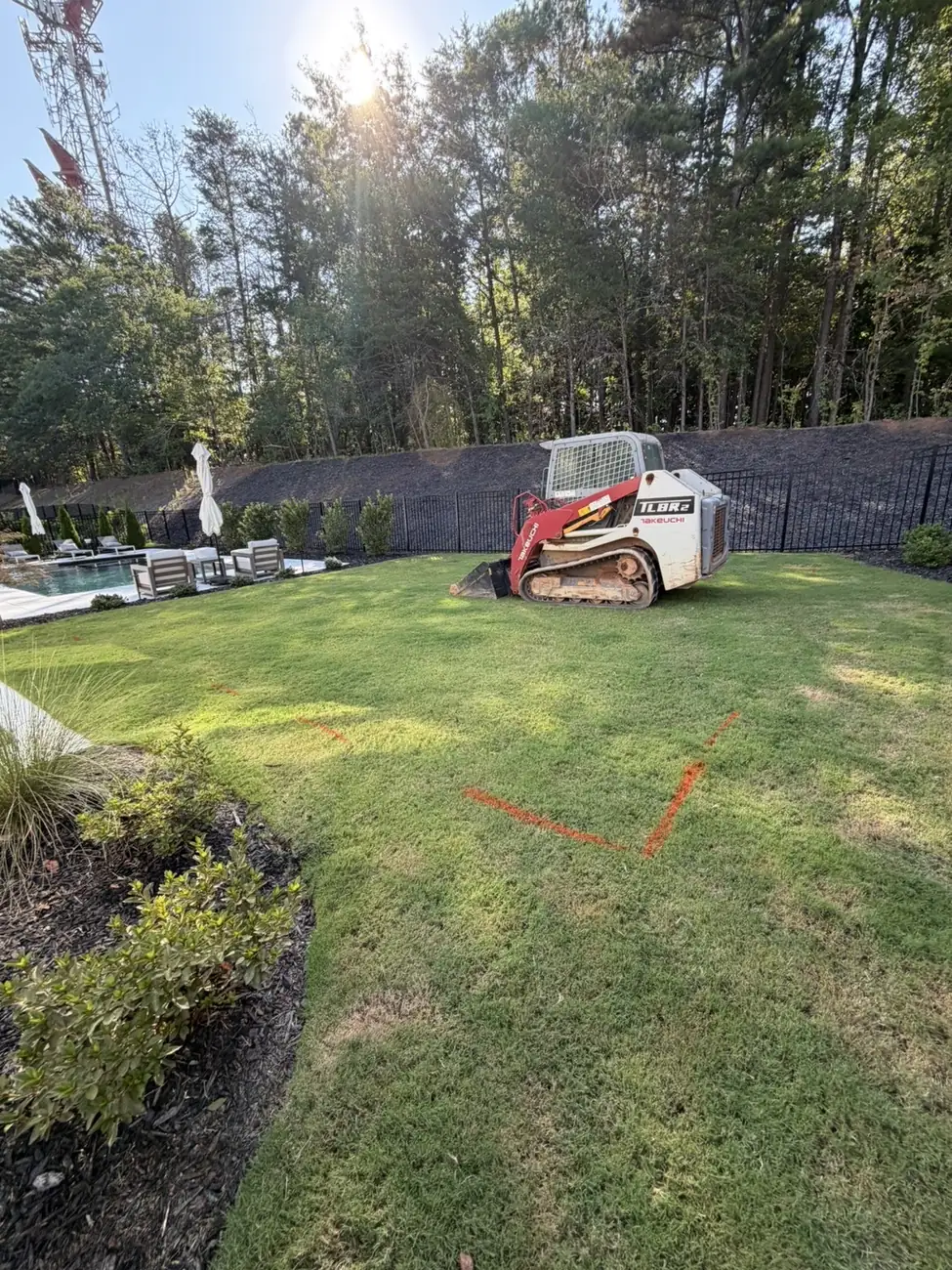 Backyard before work, with a B&B track loader on site